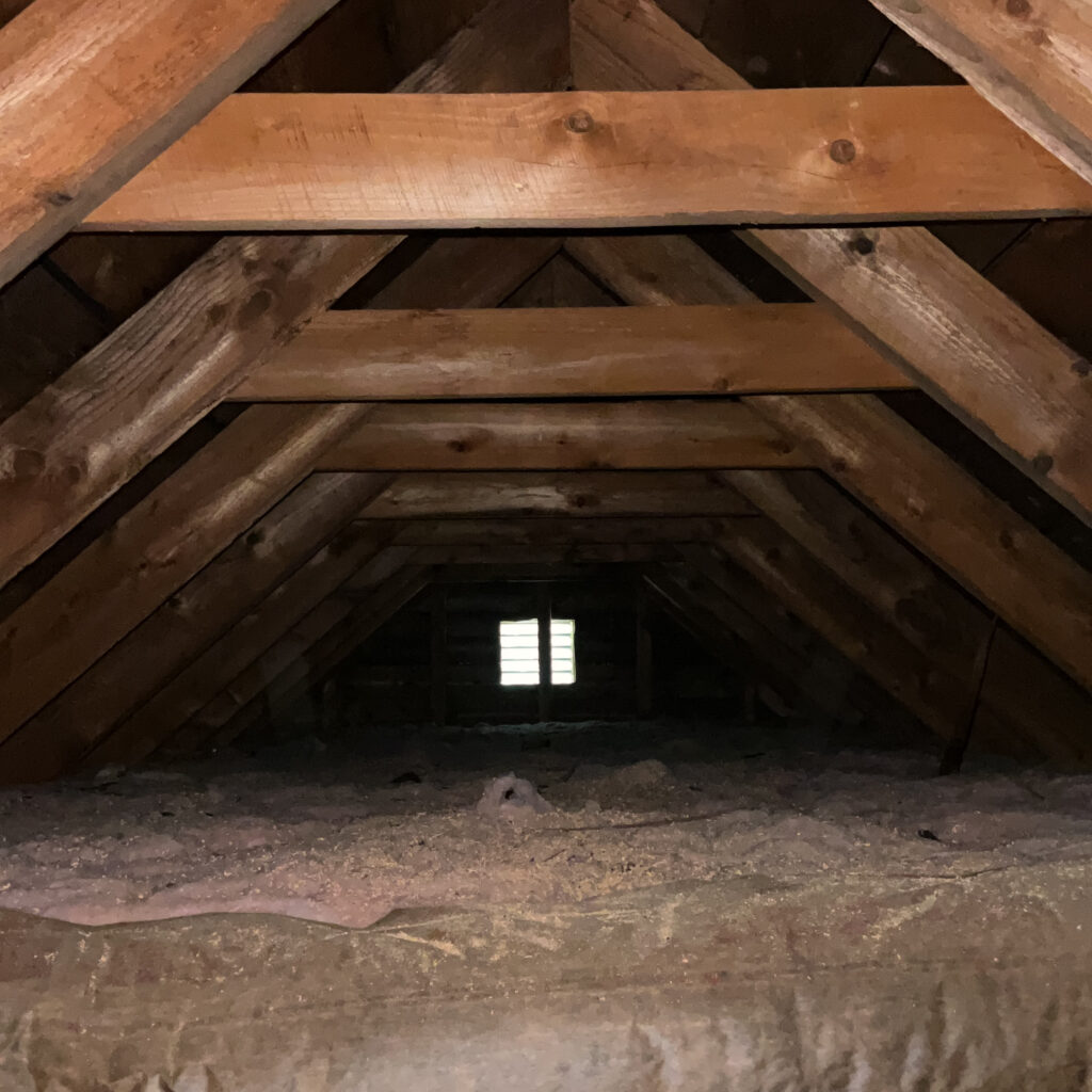 Attic inspection photo showing roof framing and insulation levels during a Yankee Home Inspections service in Central Maine.